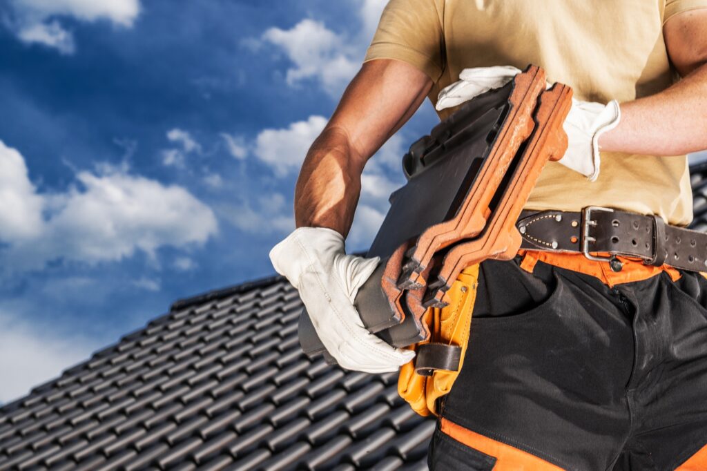 Roofing Worker Moving a Black Roof Ceramic Tiles